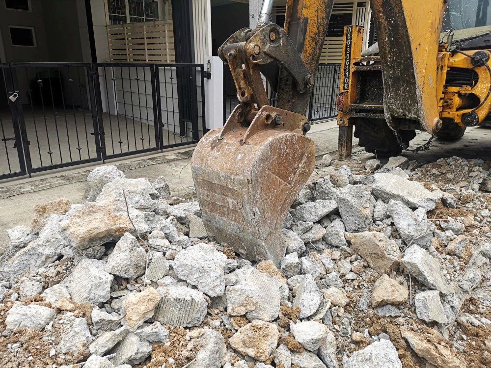 Heavy equipment breaking concrete pavement during residential excavation project in Los Angeles