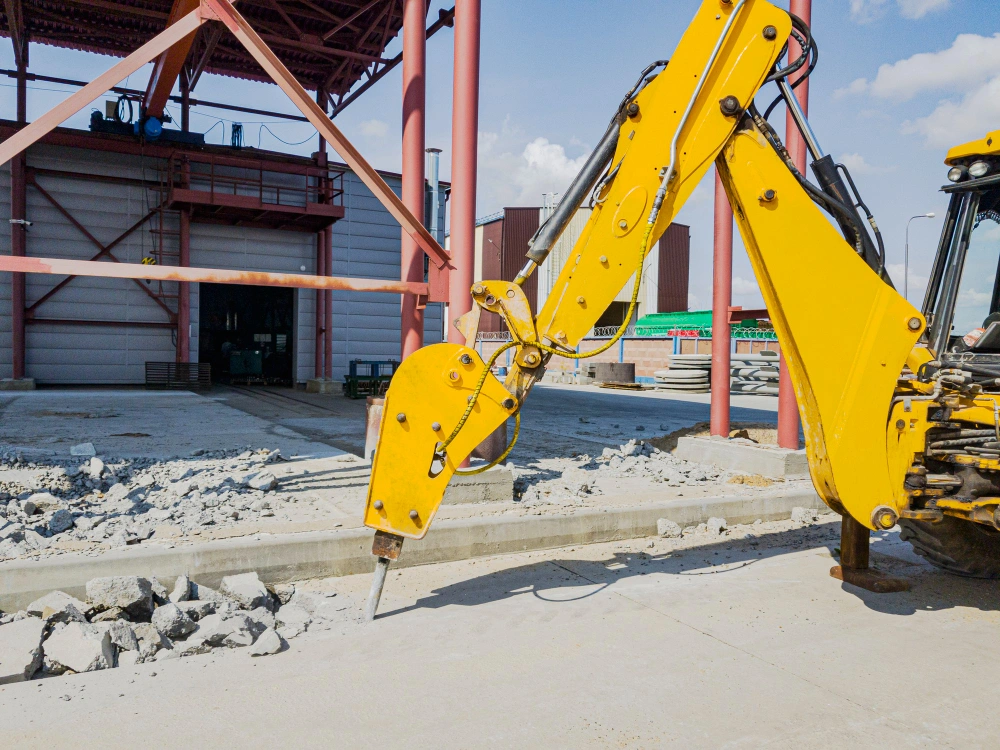 Professional concrete and asphalt breaking services performed by excavator on Los Angeles job site