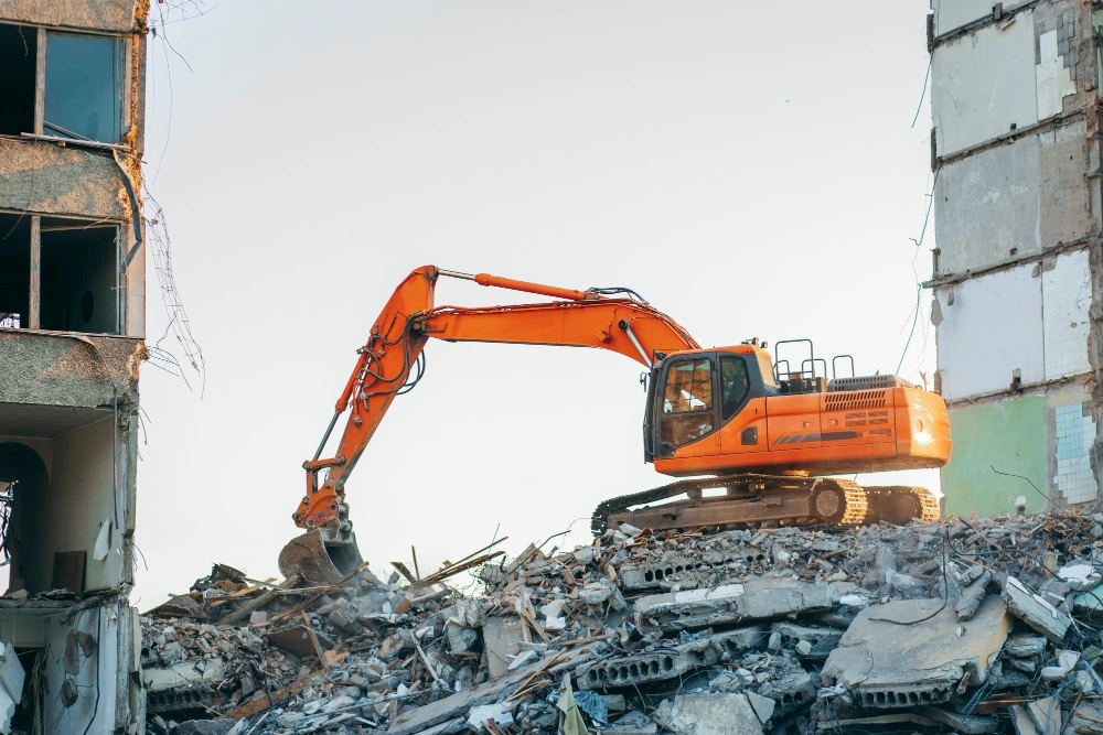 Heavy excavator performing structural demolition on multi-story building in Los Angeles