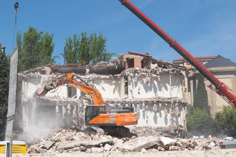 Professional demolition services with excavator dismantling building structure in Los Angeles