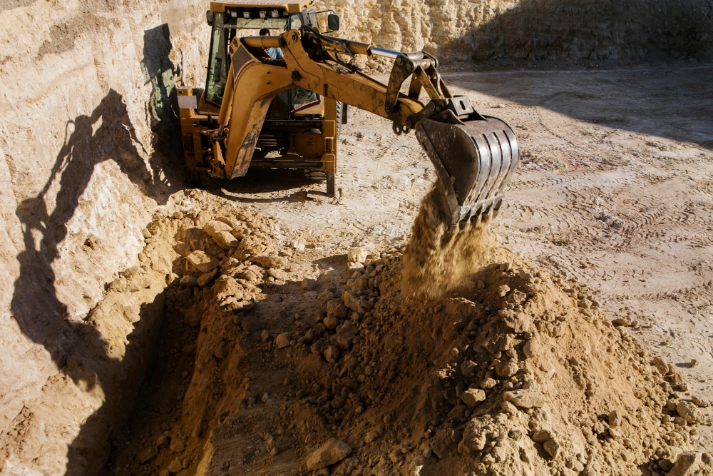 Heavy equipment performing trench excavation and soil removal on active Los Angeles construction site